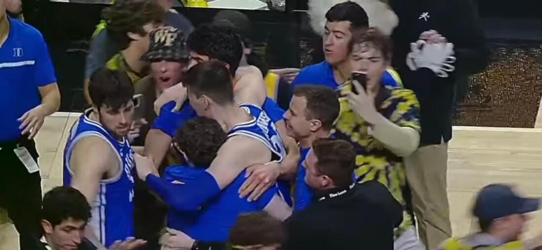 Picture: Duke player Kyle Filipowski helped off the court after collision with spectator court-rushing