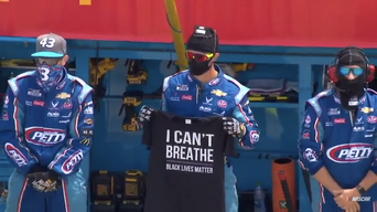 Picture: Crew member for Richard Petty Motorsports team of Darrell Wallace Jr. holds T-shirt saying 